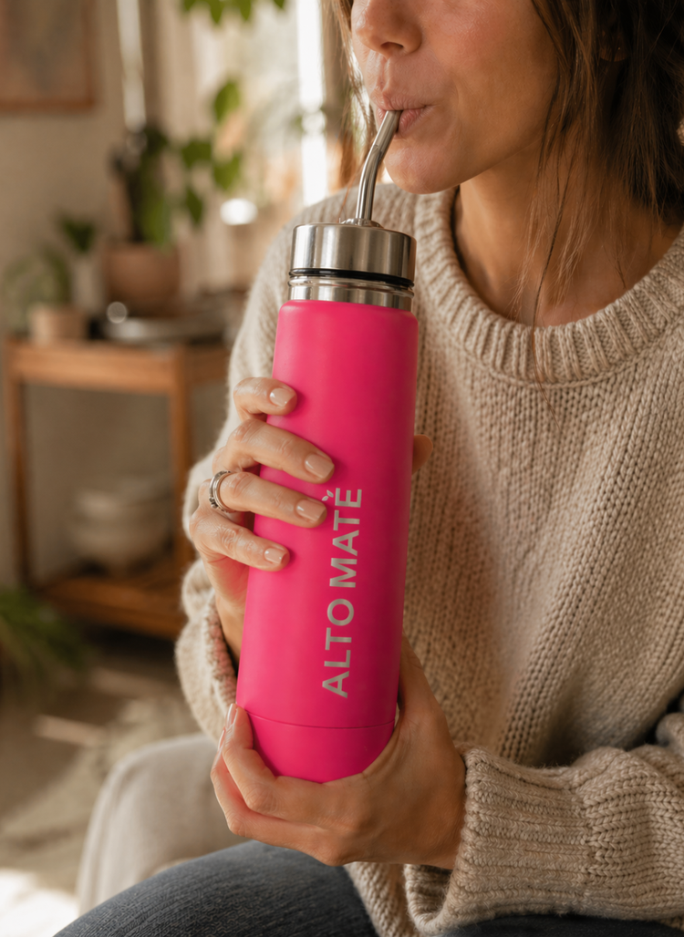 Mujer tomando mate con su ALTO MATÉ autocebante fucsia.